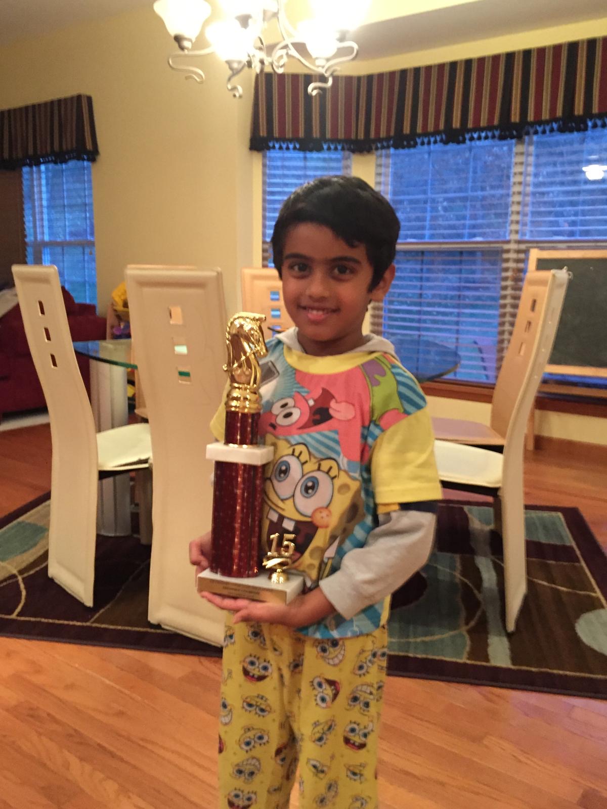 Sudeep as a young chess player, holding a tournament trophy