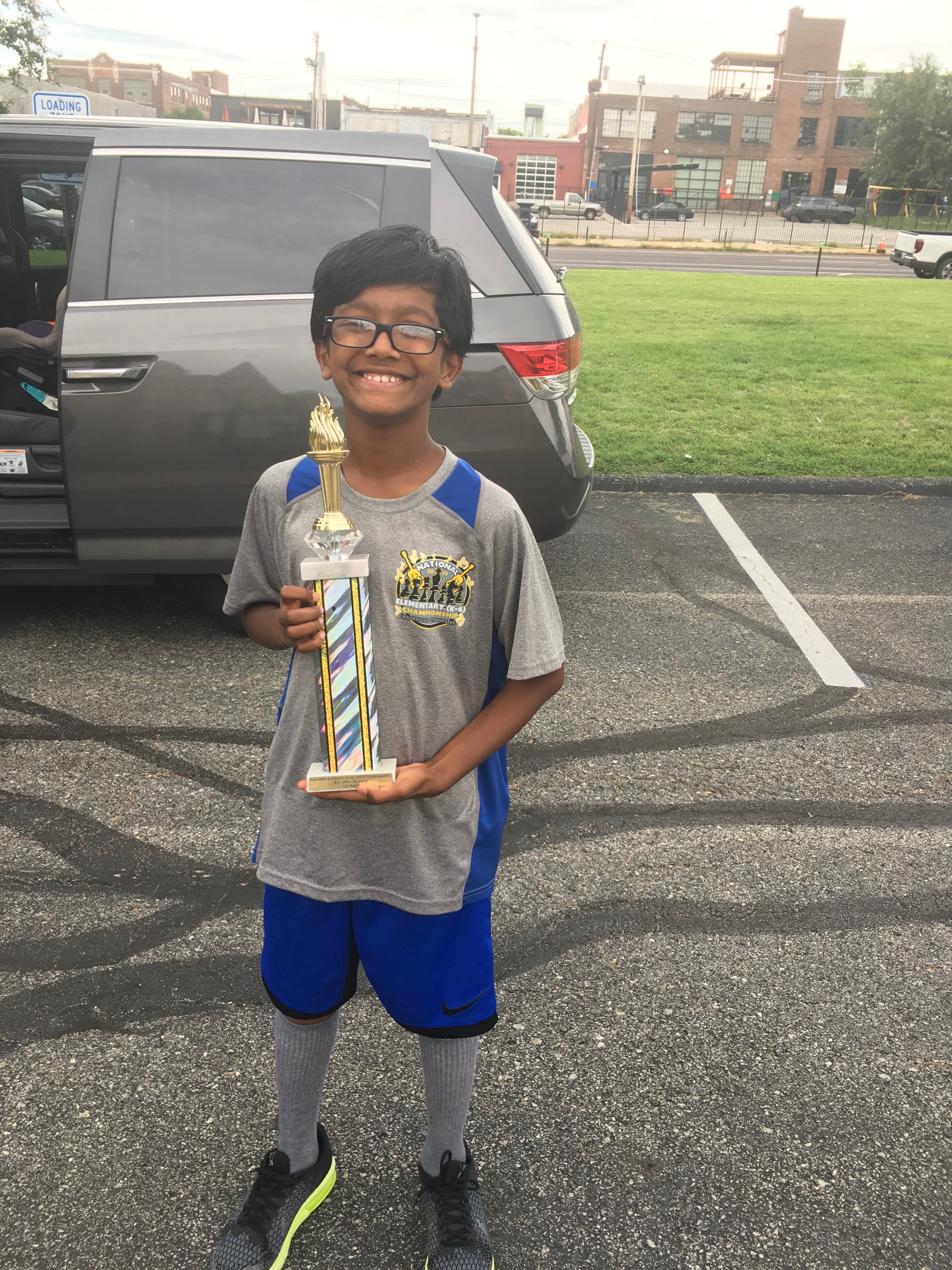 Sujay as a young chess player, holding a tournament trophy